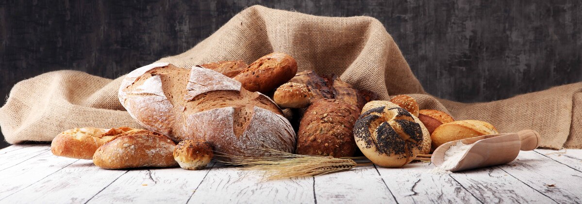 assortment,of,baked,bread,and,bread,rolls,on,wooden,table